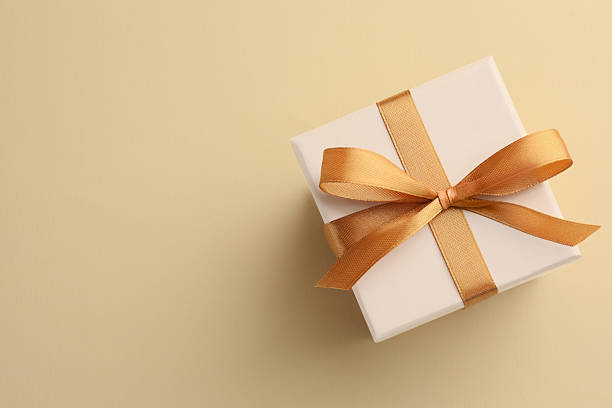 istock Beautiful gift box with golden bow on beige background, top view. Space for text 2223503340
