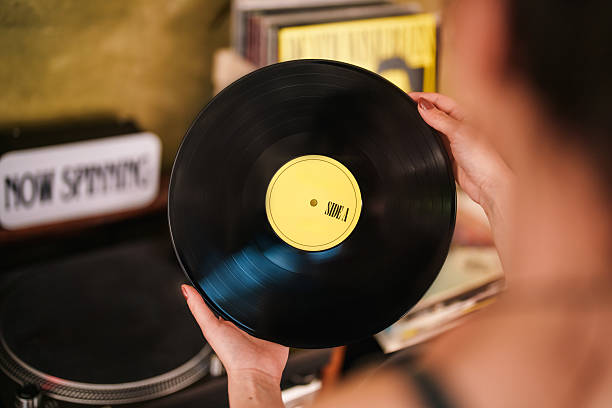 istock Woman Holding a Vinyl Record in a Cozy Retro Setting 2223504403