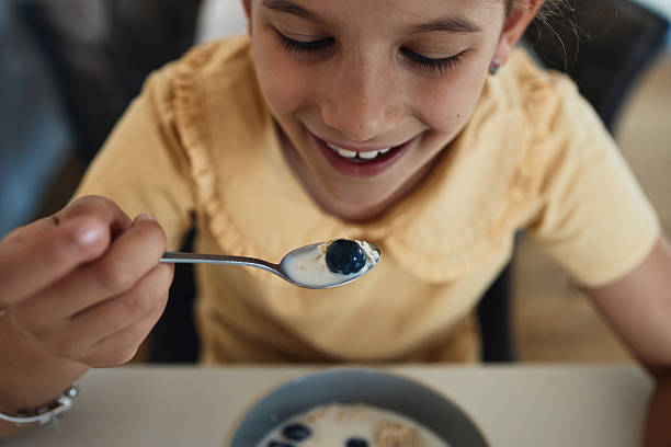 istock Young girl having breakfast at home 2223504921