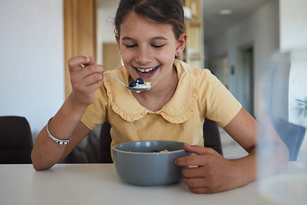 istock Young girl having breakfast at home 2223505063
