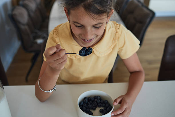 istock Young girl having breakfast at home 2223505090
