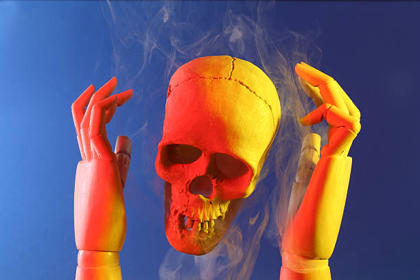 Human skull and mannequin hands on blue background