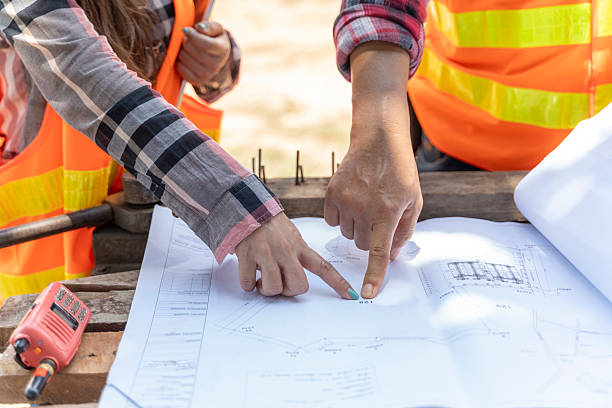 istock Construction Team Collaboration: Engineers and Architects Reviewing Building Blueprints and Project Plans On-site 2223505784