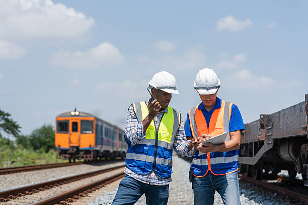 istock Railway Transportation Engineers Reviewing Construction Plans at Worksite, Team of Engineers Inspecting Bridge Construction Site, Construction Workers Discussing Project Blueprint Outdoors 2223505956