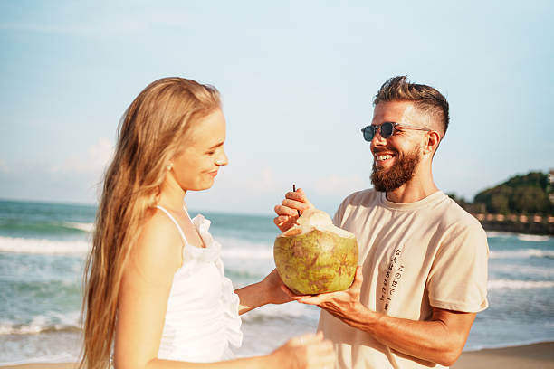 istock Joyful Couple Enjoying Coconut on a Scenic Beach 2223510330