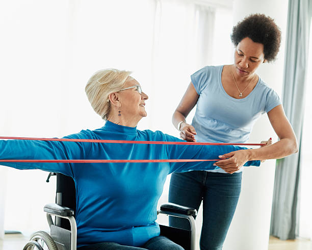 istock senior care exercise physical therapy exercising help assistence retirement home physiotherapy physiotherapist fitness gym strech band clinic therapist elderly woman band stretching 2223510755