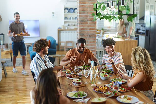 istock Diverse friends enjoying in conversation during a meal at dining table. 2223512323