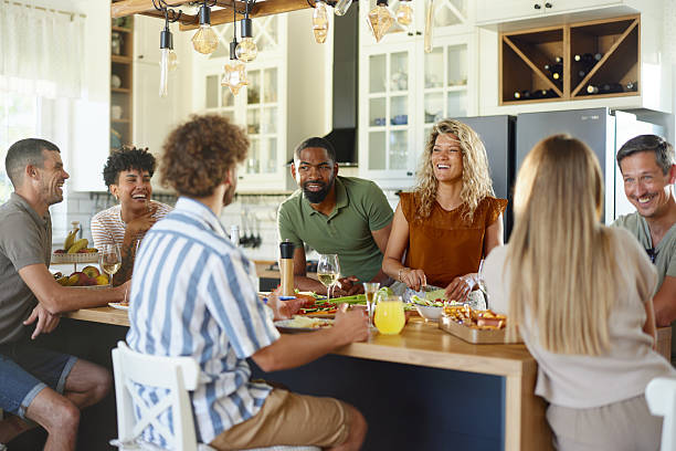 istock Group of happy friends talking at kitchen counter. 2223513734