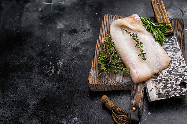 istock Freshly cut cod fish fillet, highlighting its mild taste and versatility in various dishes. black background. top view 2223514957