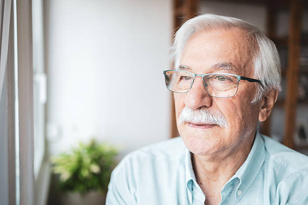 istock Senior man reflecting by the window 2223515194