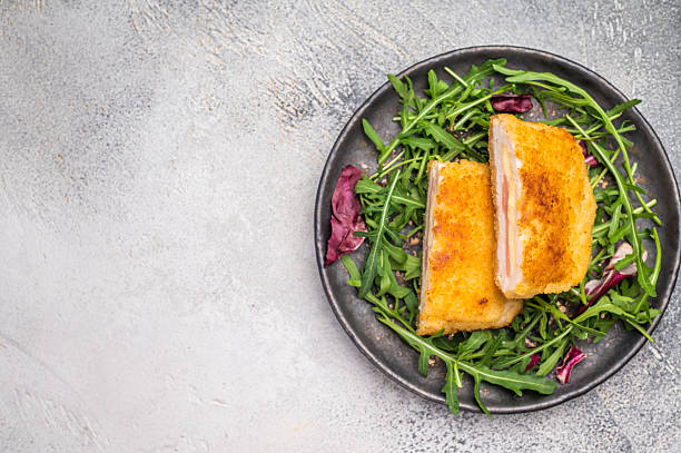 istock Fried Cordon bleu escalopes with salad on plate. white background. top view 2223517145