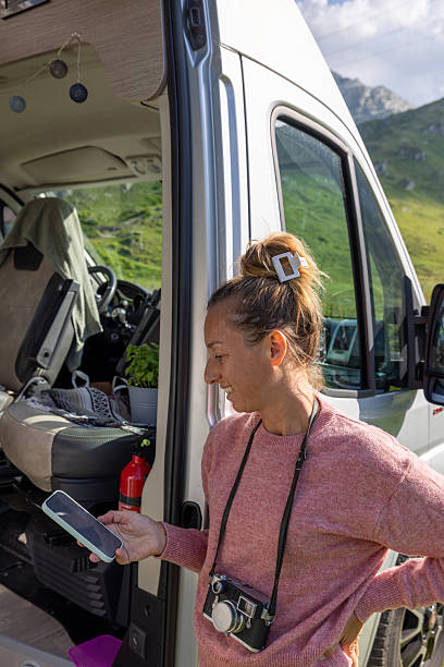 istock Woman Using Phone Outside Camper Van Door 2223521210