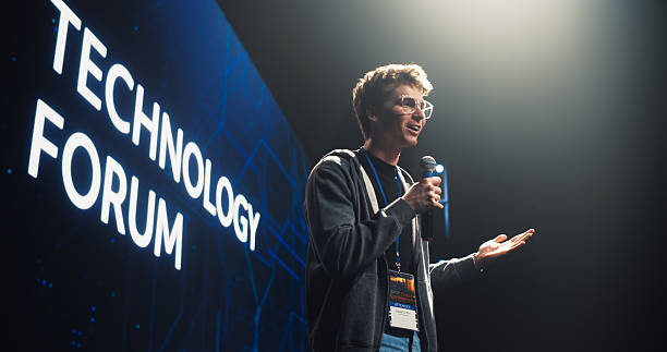 istock Startup Founder Talking About Business Partnerships and Collaborations on a Big Stage. Young Caucasian Man Talking About Future Technology Insights and Artificial Intelligence at a Global Event 2223522371