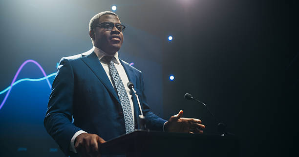 istock Black Personal Growth Keynote Speaker Delivering a Motivational Speech on Stage, Hosting a Management Seminar to Help Entrepreneurs Overcome Their Personal and Professional Challenges 2223522634