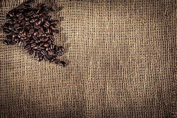 Coffee themes:  Roasted raw coffee beans on jute background with copy space