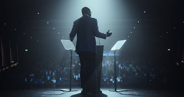 istock Anonymous Black Personal Growth Keynote Speaker Delivering a Motivational Speech on Stage, Hosting a Psychology Seminar to Help Entrepreneurs Overcome Their Personal and Professional Challenges 2223523715