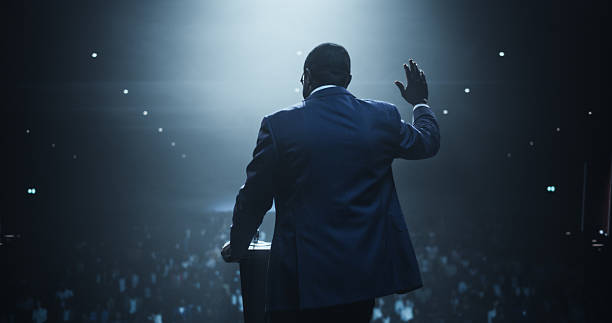 istock Anonymous Black Personal Growth Keynote Speaker Delivering a Motivational Speech on Stage, Hosting a Psychology Seminar to Help Entrepreneurs Overcome Their Personal and Professional Challenges 2223523828