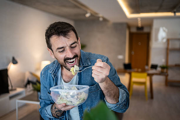 istock Happy freelancer eating salad at home office 2223526985