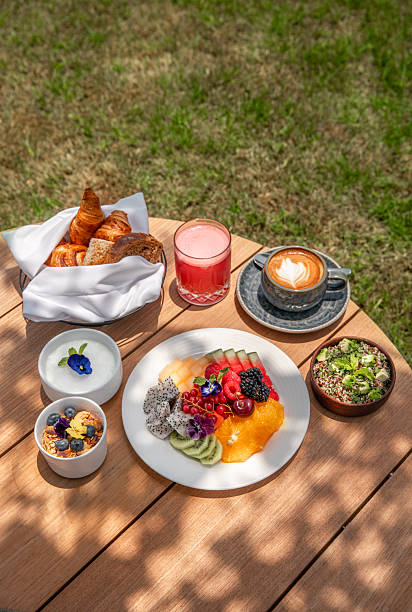 istock Healthy Breakfast variety with fruit plate, avocado quinoa salad, fruit yoghurt, bircher muesli and watermelon juice served in sunny outdoor hotel restaurant table 2223528002