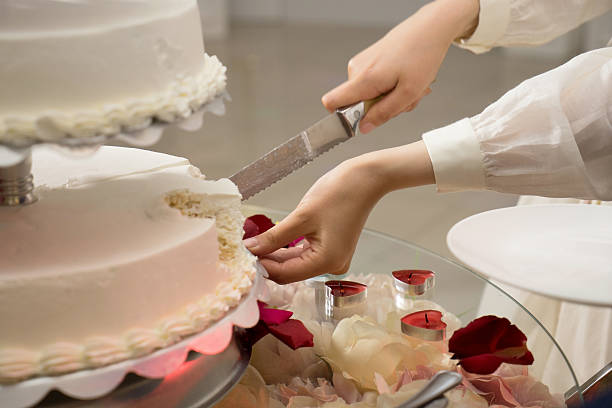 istock A bride and a groom is cutting their wedding cake. 2223529399
