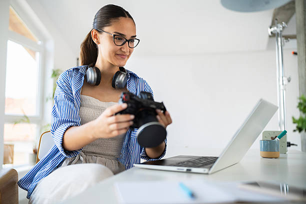 istock Young female photographer reviewing camera in a bright studio workspace 2223531747