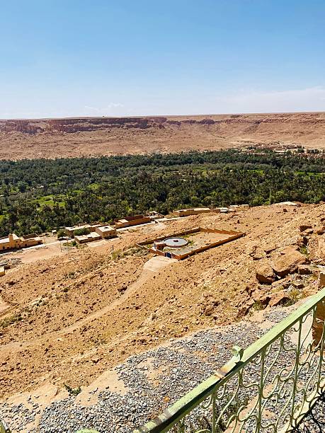 istock A desert oasis village thrives beneath a towering cliff. 2223533587