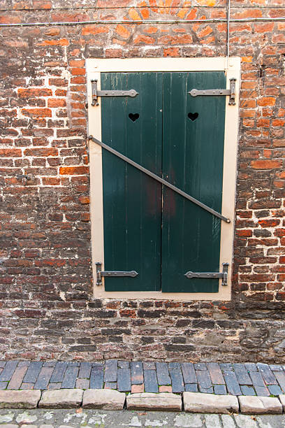 istock Locked shutters in an old brick wall 2223533641