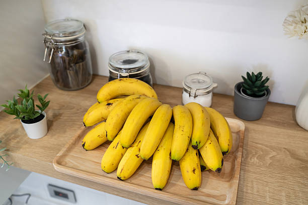 Close-up view of fresh green bananas growing on a banana tree under tropical sunny conditions within a lush environment in Siquijor, a tiny island in the Philippines.