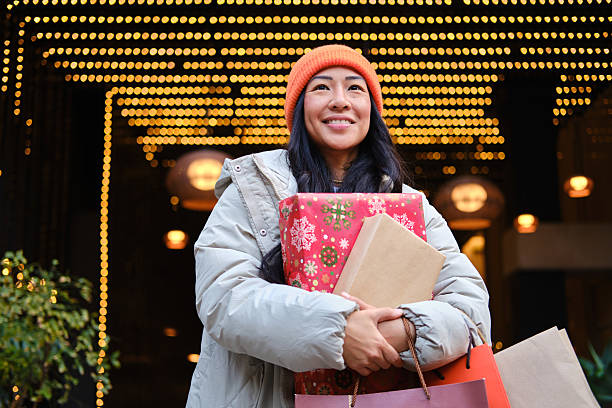 happy Young asian woman holding christmas gifts in Barcelona city center stock photo