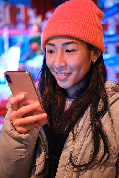 istock Young asian woman using smartphone in christmas decorated background at night 2223537162