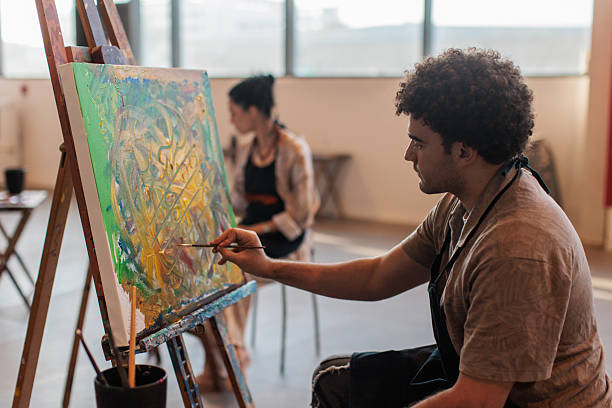istock Focused artists painting on canvas during art lesson 2223537879