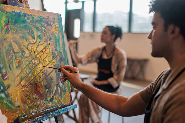 istock Art students concentrating on painting at easels 2223537895