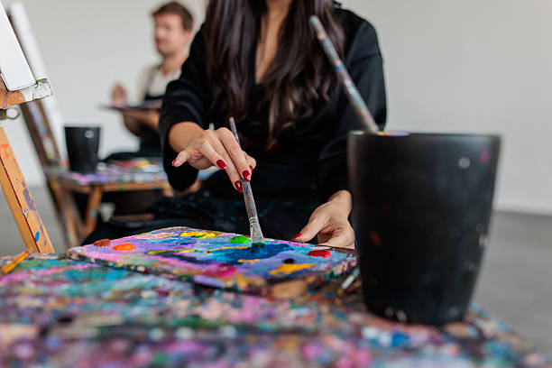 istock Art students concentrating on painting at easels 2223537973