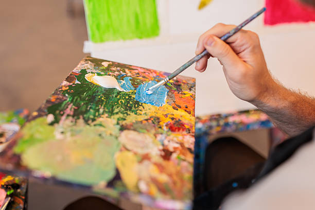 istock Man dipping paintbrush in palette 2223538574