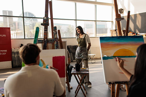 istock Art Students Painting on Easels with Teacher’s Guidance 2223538647