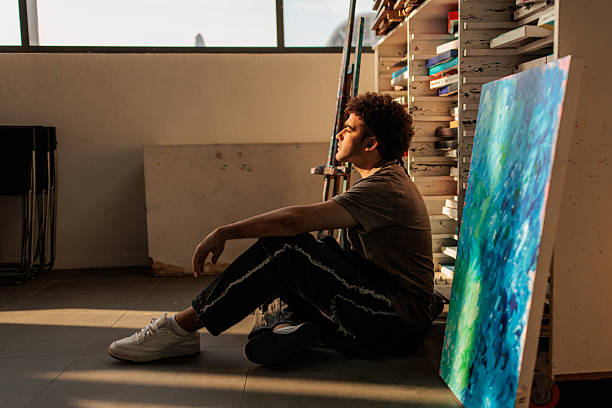 istock Man artist seated on floor in creative space 2223539020