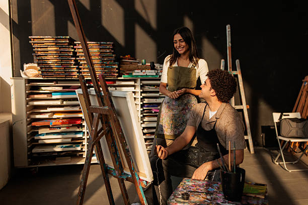 istock Art Student Painting on Easel with Teacher’s Guidance 2223539036