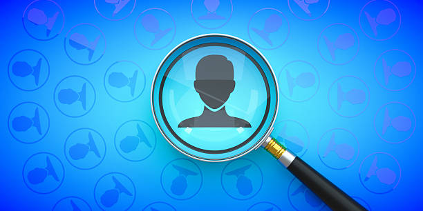 A magnifying glass highlights a single user Icon within a large group on a Blue Background. This powerful Concept symbolizes Recruitment, Human Resources, and identifying the Target Market. It visually represents the process of Analyzing data to find the right Candidate or Customer. The image is ideal for themes of Investigation, Scrutiny, and strategic Business Planning.