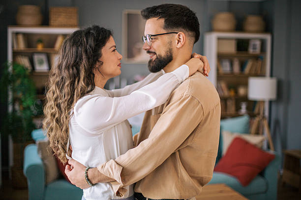 istock Young couple embracing tenderly in their cozy living room 2223539708
