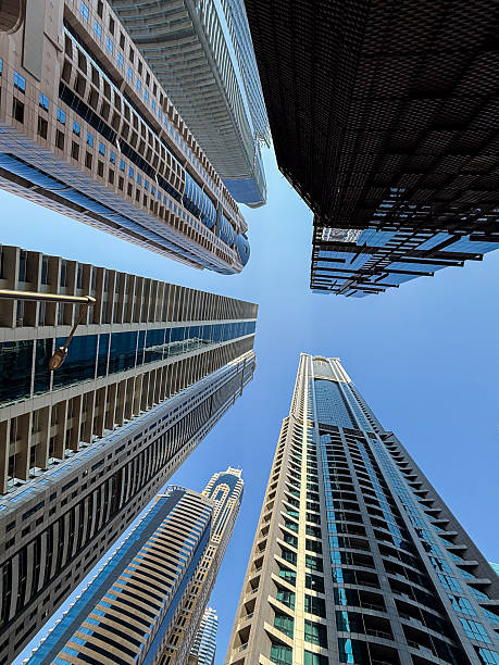 Low-angle view of towering skyscrapers in downtown Dubai, captured using a smart phone camera. A casual yet striking perspective of urban architecture.