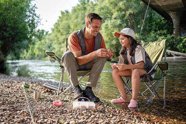 istock Father teaching his daughter to fly fish by a tranquil riverside 2223540836