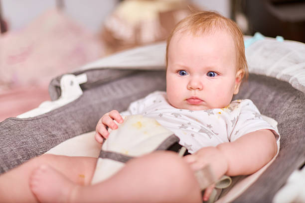istock Baby in high chair awaiting feeding, soft lighting 2223542566