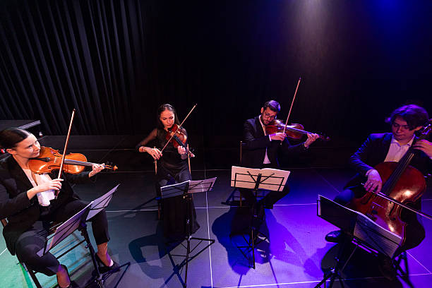 istock String quartet concert. Two violins, viola and violoncello. Talented musicians play instruments, creating graceful art on stage 2223543396