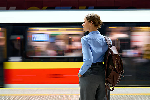 istock Woman with backpack standing at metro platform with moving train 2223544595