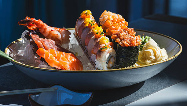 Assorted sushi platter with sashimi, nigiri, and rolls on ceramic plate
