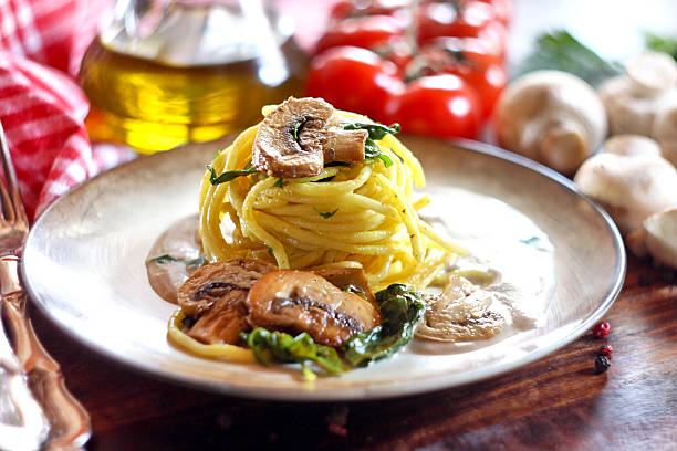 Spaghetti with mushroom and spinach on a wooden background