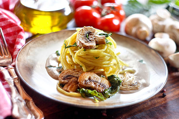 Spaghetti with mushroom and spinach on a wooden background