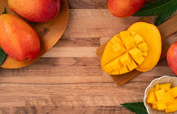 istock Fresh ripe mango with cubes on wooden table background. 2223546036