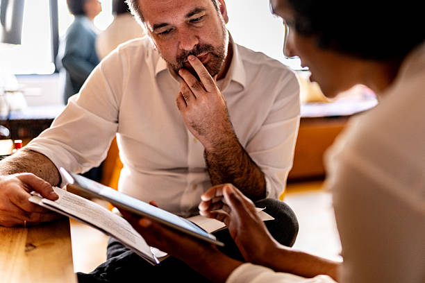 istock Mature man looking at a digital tablet that a colleague is showing at work 2223547585