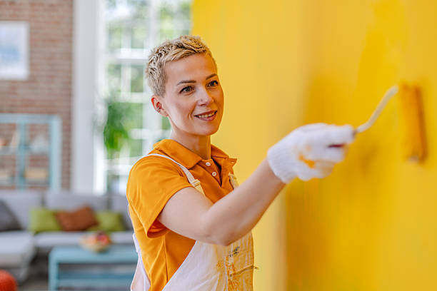 istock House painter focuses on vibrant yellow wall during indoor home improvement project in a contemporary apartment setting 2223548241